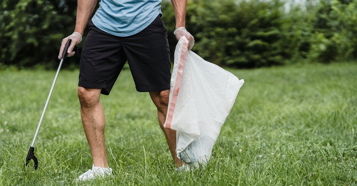 A volunteer cleaning a park, holding a grabber and garbage bag, promoting environmental well-being.